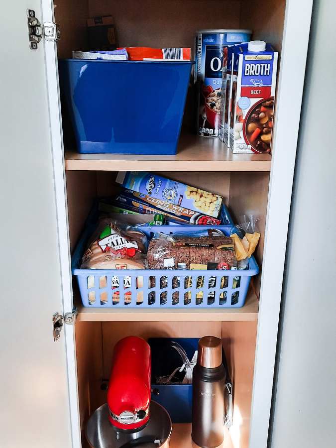 Deep kitchen pantry organized with bins and baskets from the Dollar Tree