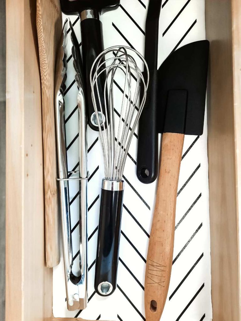 Kitchen utensils organized in a small wooden drawer